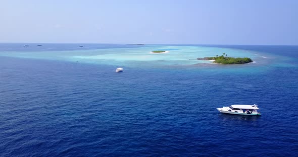 Daytime above island view of a paradise sunny white sand beach and aqua blue water background 