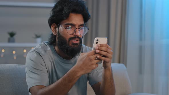 Serious Busy Arabian Indian Man Bearded Male in Glasses Typing Browsing in Smartphone Texting