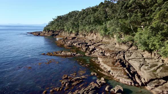 Aerial Tracking Along Goat Island Sharp And Chiseled Rocky Shoreline Unveiling Immense And Smooth Pa