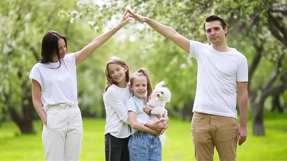 Adorable Family in Blooming Cherry Garden on Beautiful Spring Day