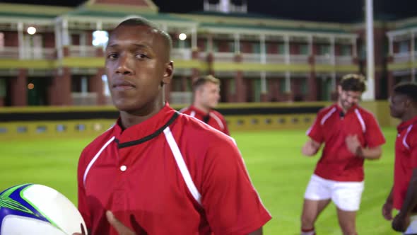 Male rugby player standing with rugby ball in stadium 4k