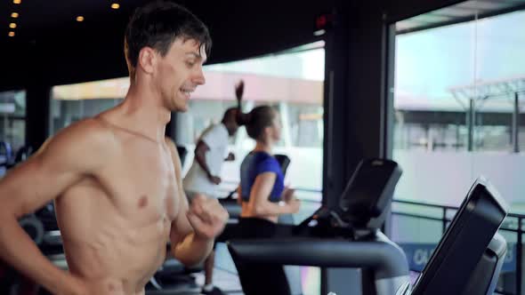 Male and female running on a treadmill at gym