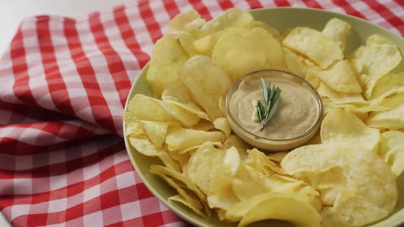 Video of crisps and cheese dip on a wooden surface