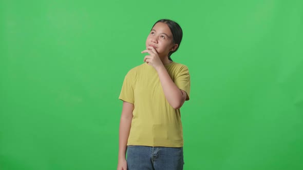 Young Asian Kid Girl Thinking About Something Then Raising Her Index Finger On Green Screen