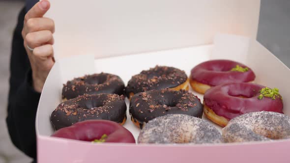 Close Up of Person Opening a Box with Dozen Colourful Vegan Doughnuts