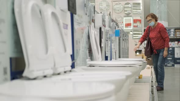 Senior Woman in Safety Mask Choosing Toilet Basin