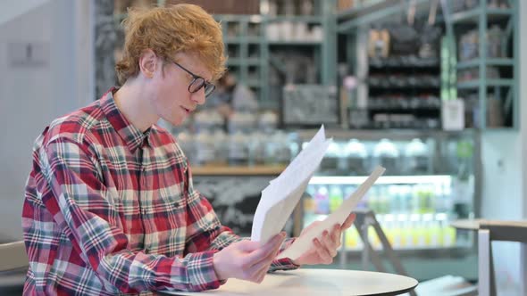 Angry Redhead Man Reacting to Loss Reading Documents