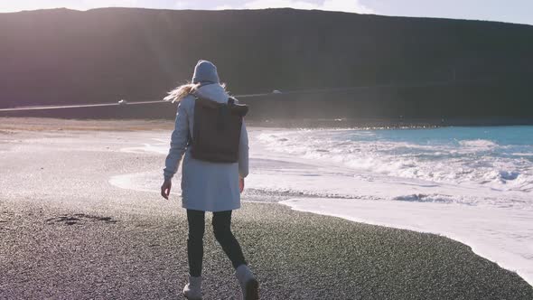 Tourist Woman with Leather Bagpack Walking Near the Coastal Landscape in Iceland Slow Motion