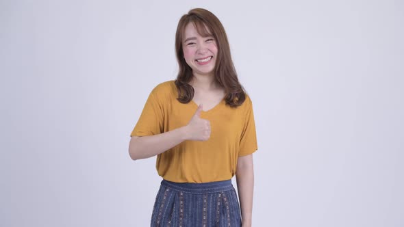 Happy Young Beautiful Asian Woman Giving Thumbs Up