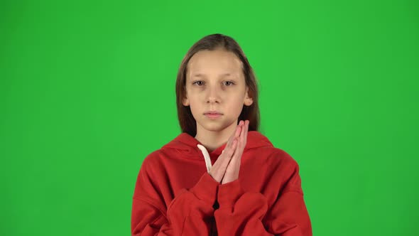 Little Female Is Clapping Her Hands and Then Smiling in Studio. Greenscreen