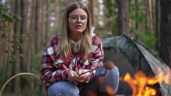 Front View Woman Cooking Mushroom on Bonfire with Red Flame Burning at Front in Slow Motion