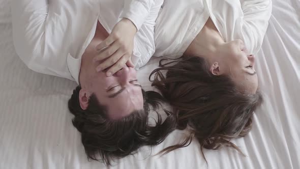 Overhead Shot Happy Young Couple Lying on the Bed Talking