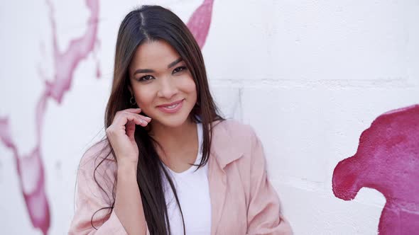 Stylish Woman with Standing Against White and Pink Wall