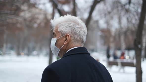 Gray Haired Gentleman Taking a Walk in Winter Garden During Covid 19 Lockdown