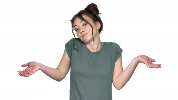 Portrait of Young Woman with Double Buns Hairstyle Shrugging and Throwing Both Hands Up Meaning Oops