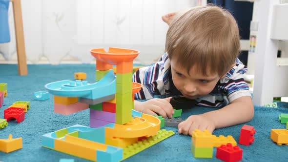 Closeup Video of Happy Smiling Boy Having Fun While Watching Marble Run Made of Colorful Building