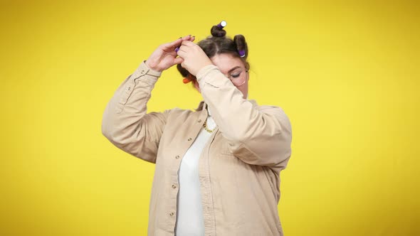 Young Overweight Woman Applying Hair Curlers Looking at Camera