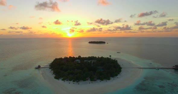 Aerial drone view of scenic tropical islands at sunset in the Maldives.