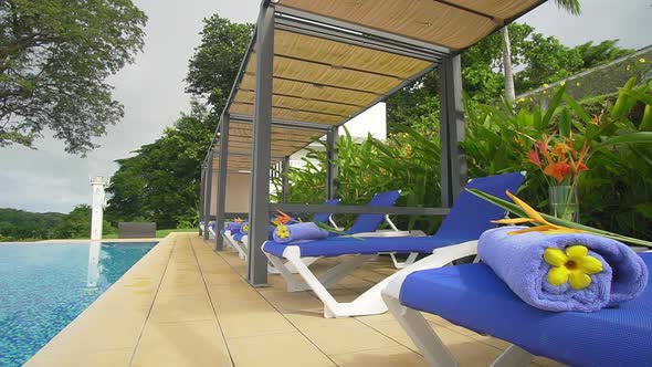 Laying chairs by the pool in a tropical environment, cloudy sky at day time. Boca, Chica, Panama.