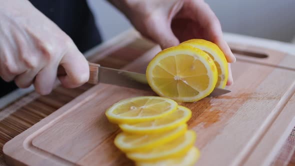 Woman Cutting a Lemon on the Chopping Board