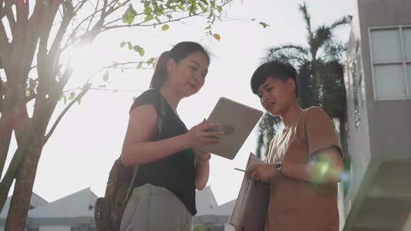 Education and student. Two Asian student talking with digital tablet in college. alt