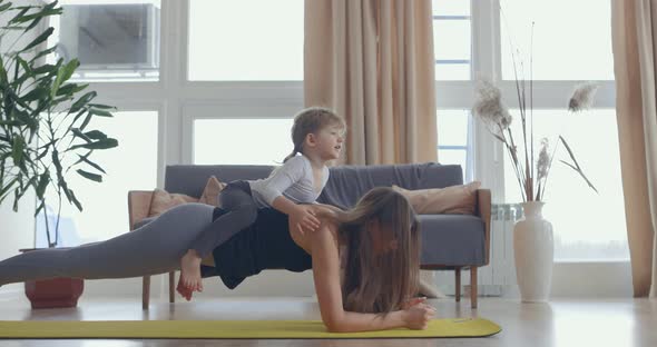 Young Beautiful Woman and Her Little Baby Girl Training Stretching Yoga at Home