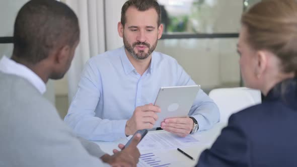 Businessman with Tablet Talking to Mixed Race Business People