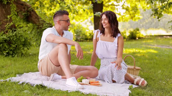 Happy Couple Having Picnic at Summer Park