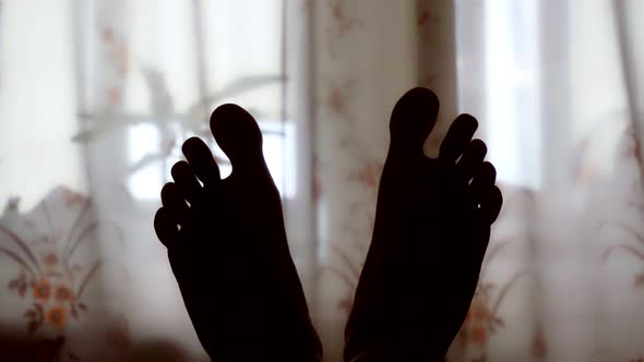 Man Kneading Feet in Bed