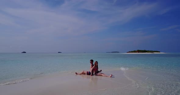 Romantic couple on honeymoon vacation live the dream on beach on clean white sand background