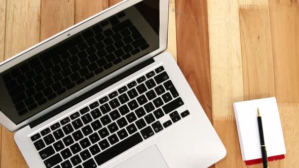 Close-up of laptop with coffee cup and notepad