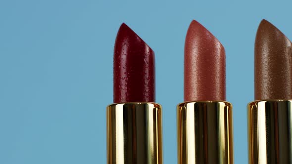 A slider of movement of lipsticks of different colors. Cosmetics for women, closeup of lipsticks