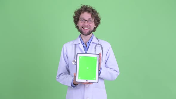 Happy Young Bearded Man Doctor Showing Digital Tablet