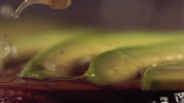 Squeezing Lemon and Olive Oil on Avocado in Slow Motion