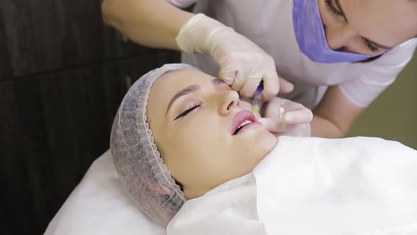 Cosmetologist Making Injection in Female Lips