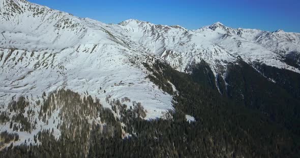 Aerial drone view of snow covered mountains in the winter.