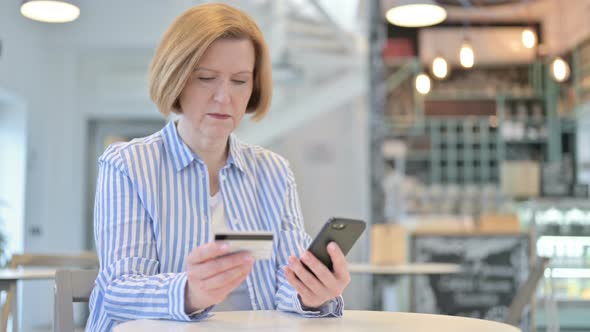 Online Payment on Smartphone By Creative Old Woman in Cafe 