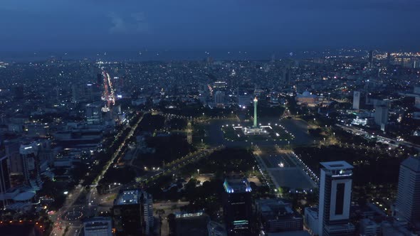 Wide Aerial Dolly View of Indonesian National Monument Monas Symbolizing Independence in Large Pubic