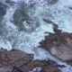 Aerial view over waves breaking onto rocks in the ocean - VideoHive Item for Sale