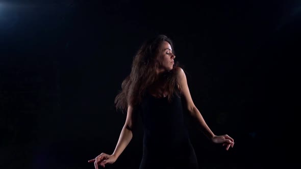 Young Slender Woman Is Dancing in Dark Studio, Rehearsal or Performance of Contemporary Dance