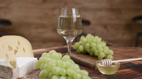 A Composition of Cheeses and a Glass of White Wine in the Center