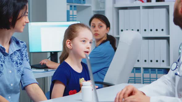 Physician Talking with Child and Mother