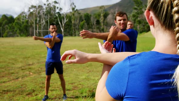 Female trainer training people in boot camp 4k