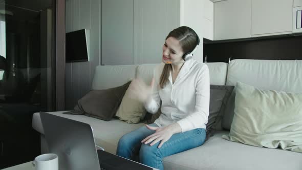 Young Business Woman Wearing Headphones Communicating By Video Call.