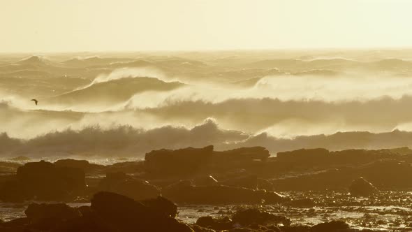 Big Waves Hitting the Rocky Shore During Sunset