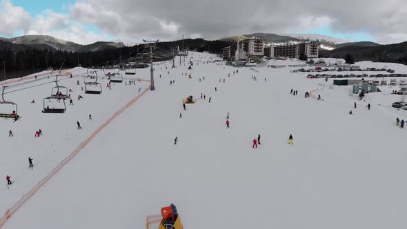 Aerial View on Lot of People Skiing on Ski Slopes Near Ski Lifts on Ski Resort