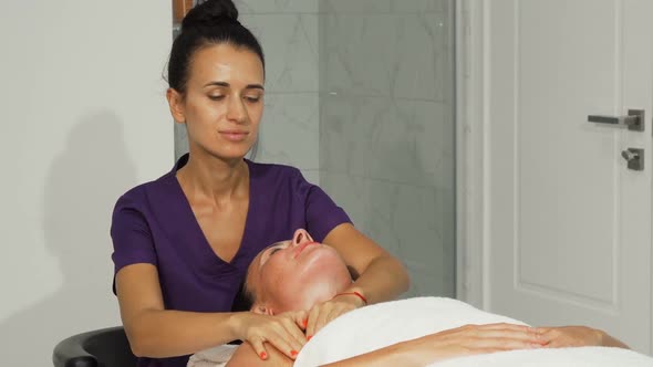 Cheerful Masseuse Smiling While Working with a Client