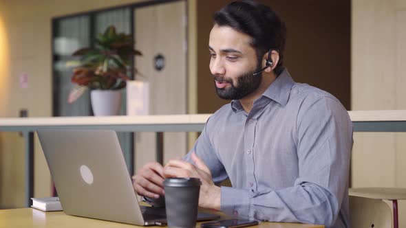 Happy Indian Business Man Talking Having Virtual Meeting Working on Laptop