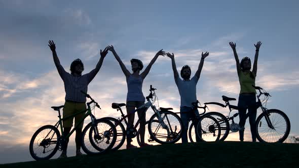 Company of Young Cyclists at Sunset Sky