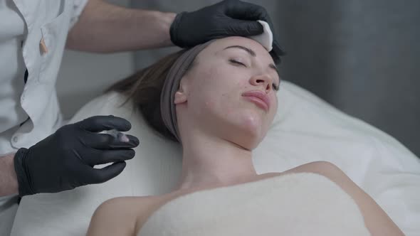 Portrait of Young Slim Caucasian Woman Lying in Beauty Parlor As Professional Cosmetologist